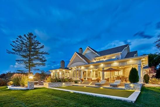 Two-story home with warm garden and porch lighting